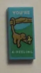 Medium Azure Tile 1 x 2 with Monkey with Banana and 'YOU'RE A-PEELING' Pattern