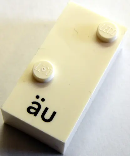 White Brick, Braille 2 x 4 with 2 Studs with Black Lowercase Letters a with Diaeresis u (äu) Pattern