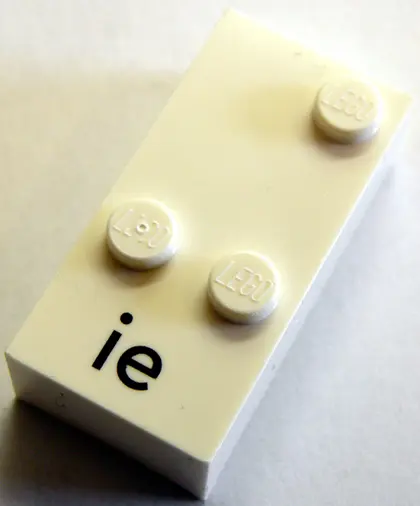 White Brick, Braille 2 x 4 with 3 Studs with Black Lowercase Letters ie Pattern (dots-346 ⠬) (German