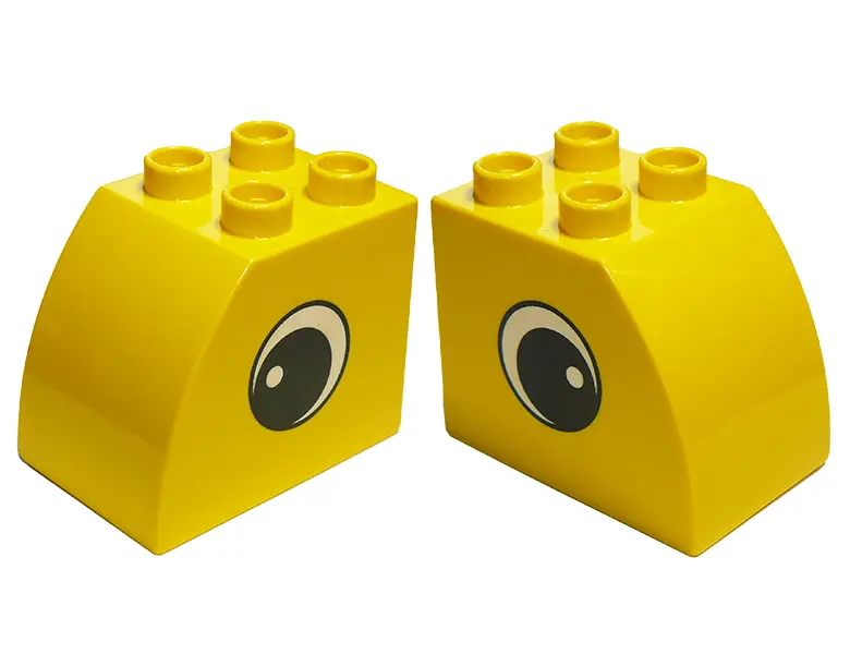 Yellow Duplo, Brick 2 x 3 x 2 Slope Curved with Circled Black Eye with White Pupil Pattern on Both S